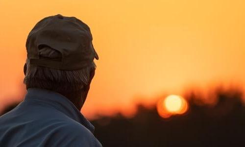 Farmer looking at sunset